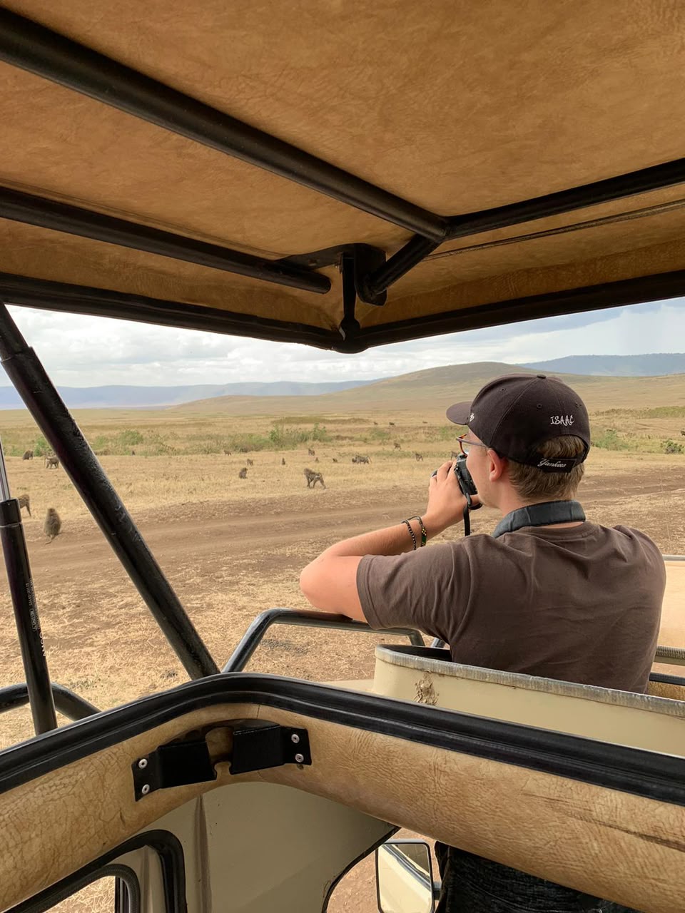 A guest photographing from the safari vehicle